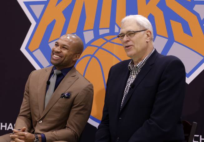 Derek Fisher, left, laughs, while New York Knicks president Phil Jackson speaks during a news conference in Tarrytown, N.Y., Tuesday, June 10, 2014. The Knicks hired Fisher as their new coach on Tuesday, with Jackson turning to one of his trustiest former players.