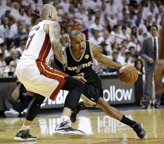 San Antonio Spurs guard Patty Mills (8) drives around Miami Heat forward Chris Andersen (11) in the second half in Game 3 of the NBA basketball finals, Tuesday, June 10, 2014, in Miami.