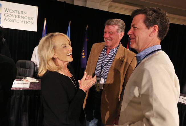 Arizona Gov. Jan Brewer, left, talks with fellow Govs. Sam Brownback of Kansas, right, and Butch Otter of Idaho, during the annual Western Governors' Association Meeting, at the Broadmoor Hotel in Colorado Springs, Tuesday, June 10, 2014. Ten governors from western states attended the second day of the conference Tuesday, discussing common regional issues.