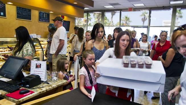 Some customers purchase their pre-ordered cupcakes as others wait patiently in line at Freed's Bakery of Las Vegas to donate and purchase some 35,000 cupcakes for $1 each on Wednesday, June 11, 2014.  The proceeds will be going to aid the families of slain Metro Police officers Metro officers Alyn Beck and Igor Soldo.