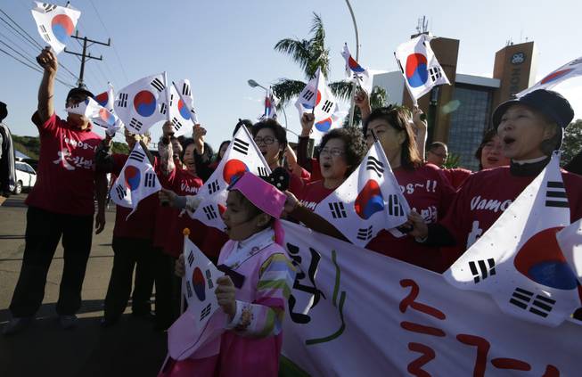 South Korean soccer fans wave their national flags as they wait for the national soccer team's arrival at the team hotel in Foz do Iguacu, Brazil, Wednesday, June 11, 2014. South Korea play in group H of the 2014 soccer World Cup. 