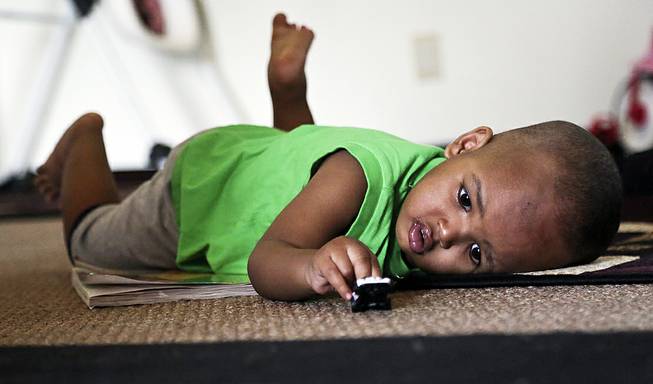 Musa Dayib, 16 months, plays with a toy car at his home Wednesday, June 11, 2014 in Minneapolis. Musa survived an 11-story fall from his home in a Minneapolis high-rise a month ago.