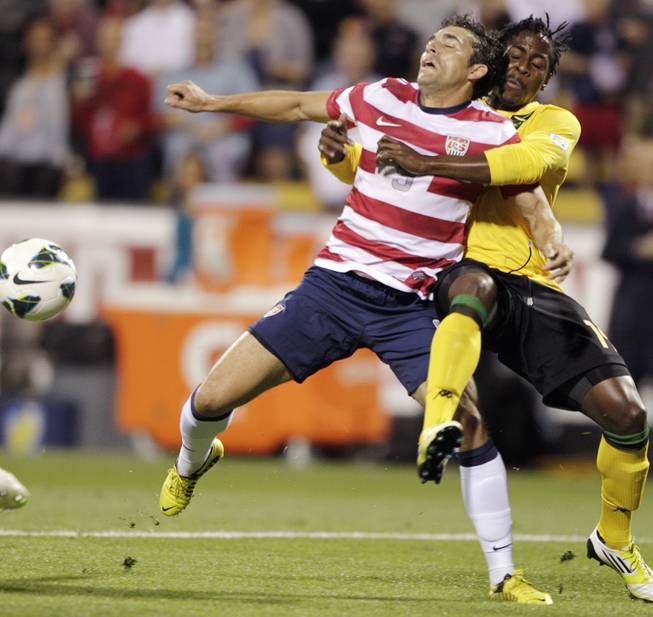 United States' Herculez Gomez, left, and Jamaica's Lovel Palmer fight for a loose ball during the first half of a World Cup qualifying soccer match, Tuesday, Sept. 11, 2012, in Columbus, Ohio. 
