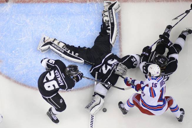 Los Angeles Kings goalie Jonathan Quick makes a save as New York Rangers right wing Derek Dorsett (15) fights for the puck during the second period of Game 5 of the NHL Stanley Cup Final series Friday, June 13, 2014, in Los Angeles. (AP Photo/Mark J. Terrill)