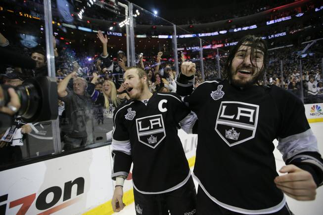 Los Angeles Kings right wing Dustin Brown, left, and teammate defenseman Drew Doughty celebrate after beating the New York Rangers in overtime in Game 5 of the NHL Stanley Cup Final series Friday, June 13, 2014, in Los Angeles. (AP Photo/Jae C. Hong)