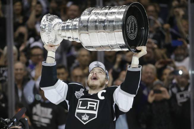 Los Angeles Kings right wing Dustin Brown raises the Stanley Cup after beating the New York Rangers in overtime in Game 5 of the NHL Stanley Cup Final series Friday, June 13, 2014, in Los Angeles. (AP Photo/Jae C. Hong)