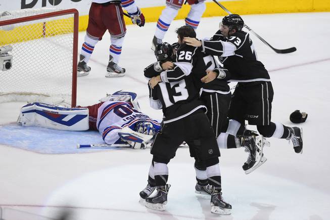 The Los Angeles Kings celebrate as New York Rangers goalie Henrik Lundqvist, of Sweden, lies on the ice behind, after the Kings beat the Rangers in double overtime in Game 5 of the NHL Stanley Cup Final series Friday, June 13, 2014, in Los Angeles. (AP Photo/Mark J. Terrill)
