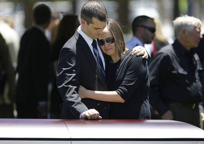 Joseph Beck, left, embraces an unidentified woman as they stand over the casket of Beck's brother Las Vegas Metropolitan Police Officer Alyn Beck during a memorial at The Smith Center for the Performing Arts Saturday, June 14, 2014 in Las Vegas. Two suspects shot and killed Beck, 41, and fellow police officer Igor Soldo, 31, in an ambush at a Las Vegas restaurant Sunday, June 8, 2014, before fatally shooting a third person inside a nearby Wal-Mart, authorities said.