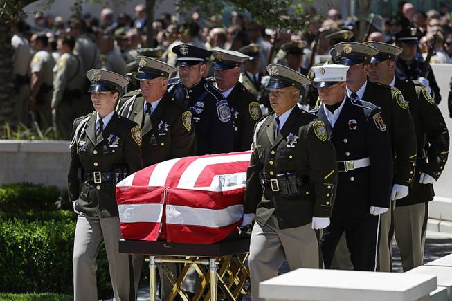 Pallbearers move the casket of Las Vegas Metropolitan Police Officer Alyn Beck during a memorial at The Smith Center for the Performing Arts Saturday, June 14, 2014 in Las Vegas. Two suspects shot and killed Beck, 41, and fellow police officer Igor Soldo, 31, in an ambush at a Las Vegas restaurant Sunday, June 8, 2014, before fatally shooting a third person inside a nearby Wal-Mart, authorities said.