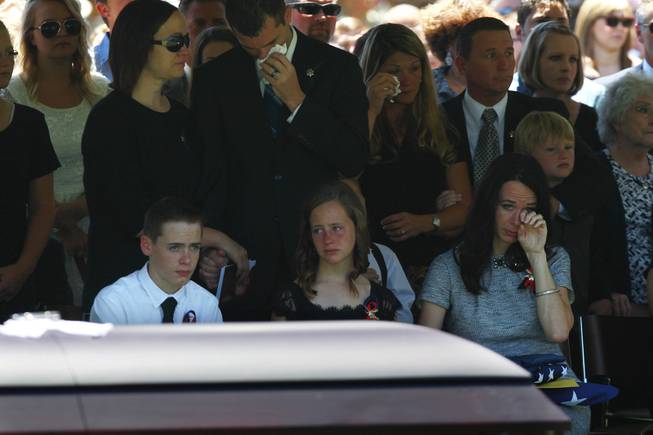 Nicole Beck wipes away a tear as she sits with son Daxton Beck, left, and Avenlee Beck during a memorial for Beck's husband and the children's father Metro officer Alyn Beck at The Smith Center for the Performing Arts Saturday, June 14, 2014.