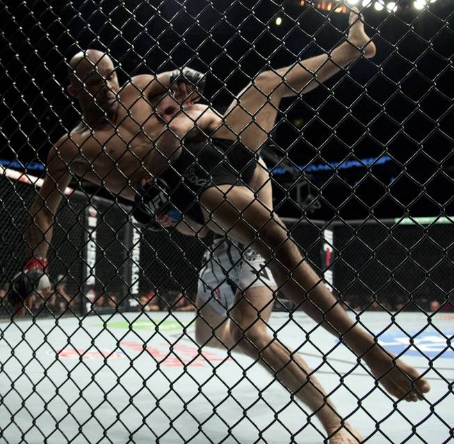 Demetrious Johnson, of the United States, left, gets thrown by Ali Bagautinov, of Russia, during the flyweight bout at UFC 174 in Vancouver, British Columbia, Saturday, June, 14, 2014.