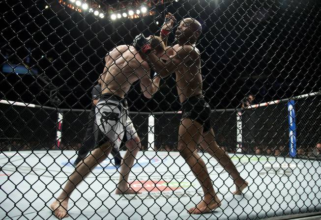 Demetrious Johnson, of the United States, right, fights Ali Bagautinov, of Russia, during the flyweight bout at UFC 174 in Vancouver, British Columbia, Saturday, June, 14, 2014.