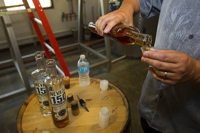 Mike Derby pours samples of "Nevada 150" bourbon whiskey during "Bourbon Day" at the Las Vegas Distillery in Henderson Saturday, June 14, 2014. The bourbon, the first bourbon produced in Nevada, is named for Nevada's sesquicentennial.