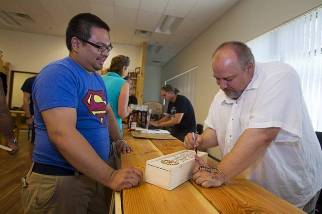 Bilson Perez has his box of bourbon signed by Las Vegas Distillery owner George Racz during "Bourbon Day" at the distillery in Henderson Saturday, June 14, 2014. The "Nevada 150" bourbon whiskey, the first bourbon produced in Nevada, is named for Nevada's sesquicentennial.