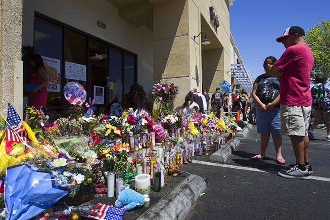 Chuck Chagoya and his daughter Rianna, 13, look over a memorial during "Sharing Our Support," a fundraiser for the families of Metro Police Officers Igor Soldo and Alyn Beck, at CiCi's Pizza Sunday, June 15, 2014. The officers were ambushed and killed at the restaurant while eating lunch on Sunday, June 8. One hundred percent of the Sunday sales will go the families of the fallen officers and Joseph Willcox, the victim killed at the Wal-Mart, said store owner Mike Haskins.