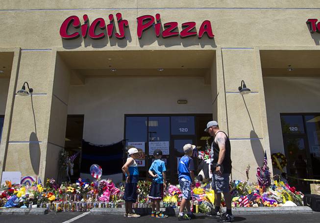 Jarod Gaskins and his sons look over a memorial during "Sharing Our Support," a fundraiser for the families of Metro Police Officers Igor Soldo and Alyn Beck, at CiCi's Pizza Sunday, June 15, 2014. The officers were ambushed and killed at the restaurant while eating lunch on Sunday, June 8. One hundred percent of the Sunday sales will go the families of the fallen officers and Joseph Willcox, the victim killed at the Wal-Mart, said store owner Mike Haskins.