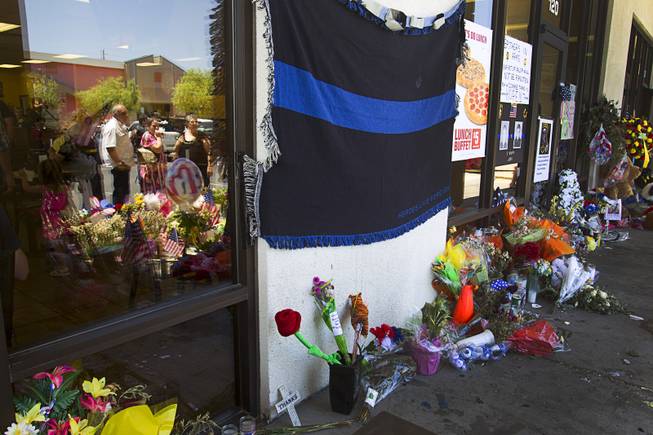 Onlookers are reflected in the window during "Sharing Our Support," a fundraiser for the families of Metro Police Officers Igor Soldo and Alyn Beck, at CiCi's Pizza Sunday, June 15, 2014. The officers were ambushed and killed at the restaurant while eating lunch on Sunday, June 8. One hundred percent of the Sunday sales will go the families of the fallen officers and Joseph Willcox, the victim killed at the Wal-Mart, said store owner Mike Haskins.