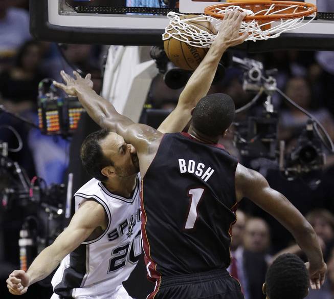 San Antonio Spurs guard Manu Ginobili (20) dunks as Miami Heat center Chris Bosh (1) defends during the first half in Game 5 of the NBA basketball finals on Sunday, June 15, 2014, in San Antonio.