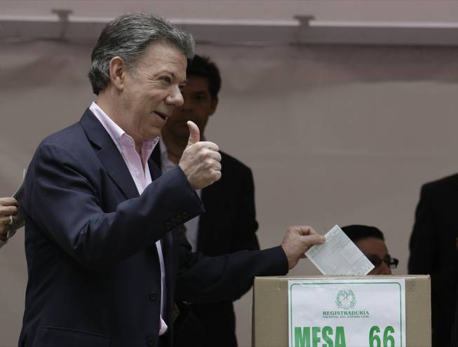 President Juan Manuel Santos casts his ballot during presidential elections in Bogota, Colombia, Sunday, June 15, 2014. Santos won a second four-year term as candidate for the Social Party of National Unity.