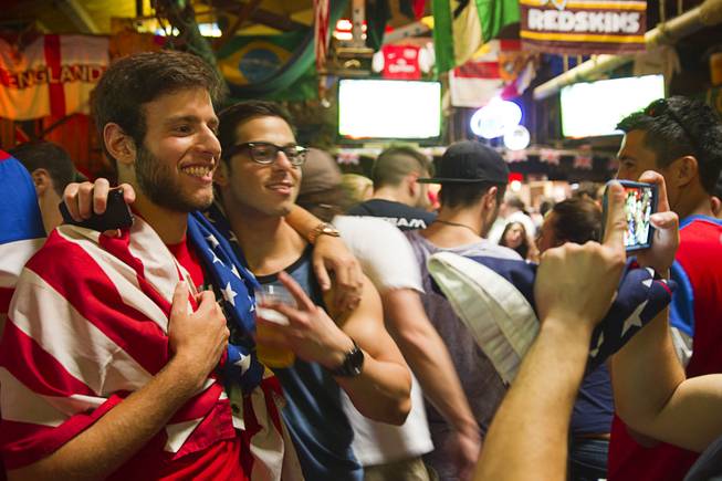 Ian Weinberg, left,  poses with a friend at halftime during a viewing party at the Crown & Anchor British Pub Monday, June 16, 2014.