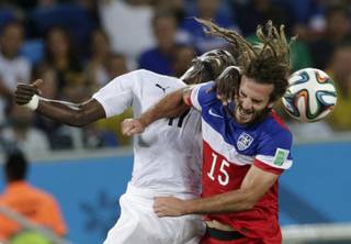Ghana's Mohammed Rabiu, left, and United States' Kyle Beckerman struggle with each other to head the ball during the group G World Cup soccer match between Ghana and the United States at the Arena das Dunas in Natal, Brazil, Monday, June 16, 2014.  (AP Photo/Petr David Josek)