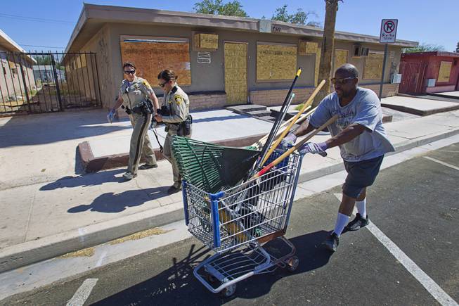 Arthur Jennings pushes a shopping cart with rakes and brooms during a Downtown Community Coalition neighborhood cleanup near Fremont Street and 21st Street Tuesday, June 17, 2014. A variety of community, church and business groups, along with Metro Police and the City of Las Vegas, participated in the event.