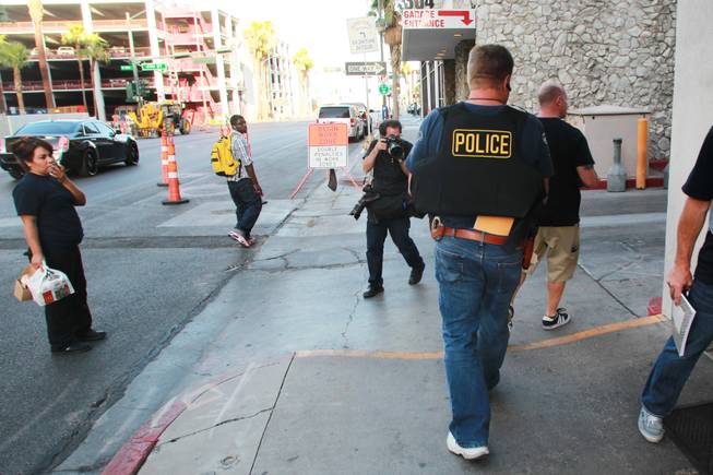 Undercover Metro officers carry away evidence from the office of Las Vegas Township Constable John Bonaventura Tuesday, June 17, 2014. Detectives were searching for evidence of illegal use of a listening device.