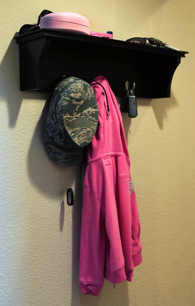 A hat and dog tags belonging to TSGT Rommel Delmundo, currently stationed at Nellis AFB, hang on a small shelf with other family possessions as they ready for another military move Monday, June 16, 2014.
