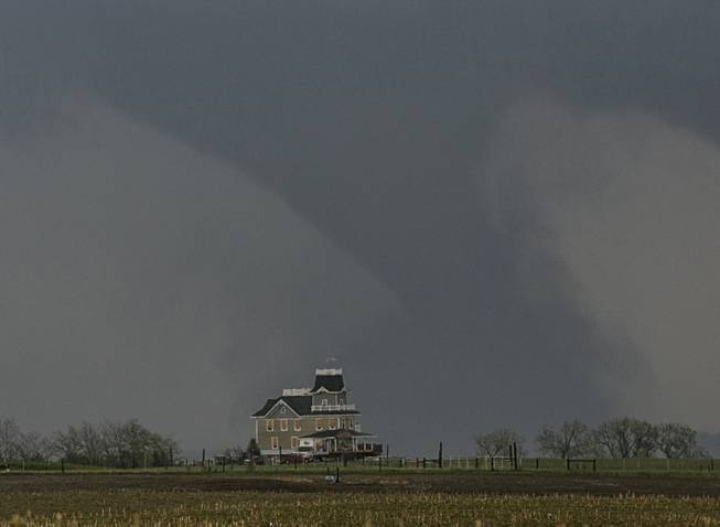 A tornado forms over a house near  Pilger, Neb., Monday, June 16, 2014. At least one person is dead and at least 16 more are in critical condition after two massive tornadoes swept through northeast Nebraska on Monday.