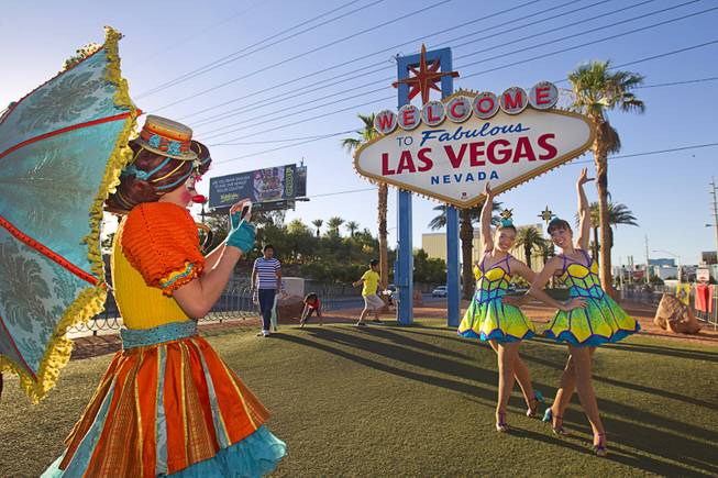 Clown Scarlett Sullivan takes a photo of Cossack Riders Albina Tanasheva and Maria Maltseva of the Ringling Bros. and Barnum & Bailey Circus at the Welcome to Fabulous Las Vegas sign Wednesday, June 18, 2014. The circus performs at Thomas & Mack Center Thursday through Sunday.