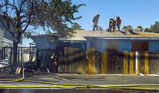 Las Vegas Fire & Rescue cut a hole in the roof during an apartment fire at 1820 East Lewis Ave. which spread to a nearby tree and shed on Thursday, June, 19, 2014.