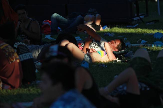 Fans seek relief from the heat under tents during the Las Vegas stop of the Vans Warped Tour Thursday, June 19, 2014.
