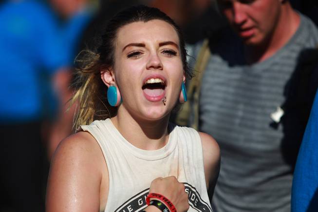 A young woman runs through the crowd during the Las Vegas stop of the Vans Warped Tour Thursday, June 19, 2014.