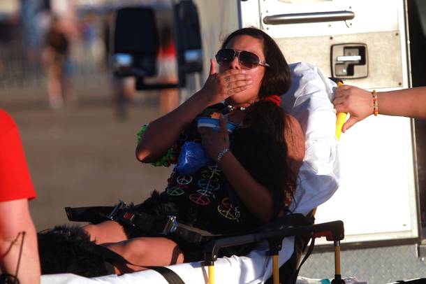 A young woman who fell ill at the entrance gate is wheeled into an ambulance during the first night of the Electric Daisy Carnival Friday, June 20, 2014 at the Las Vegas Motor Speedway.
