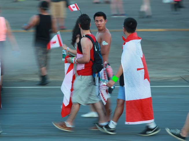 Festival goers with Canadian flags make their way to a stage during the first night of the Electric Daisy Carnival Friday, June 20, 2014 at the Las Vegas Motor Speedway.