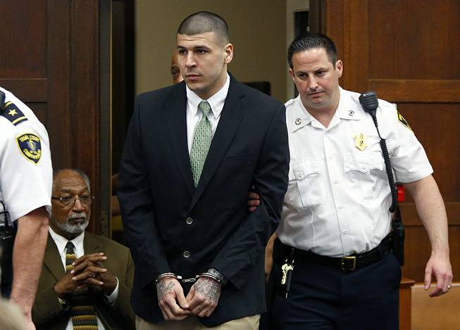 Former New England Patriots football player Aaron Hernandez is led into the courtroom to be arraigned on homicide charges at Suffolk Superior Court in Boston, May 28, 2104.