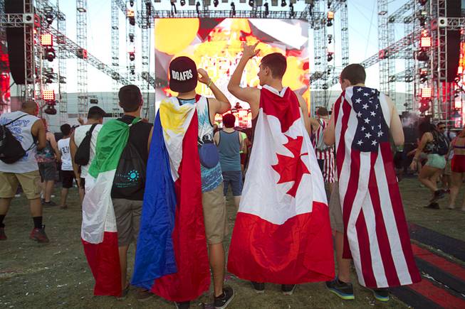Fans with flags, representing from left, Mexico, Philippines, Canada and the USA, listen to music by Henry Fong during the final day of the 2014 Electric Daisy Carnival (EDC) at the Las Vegas Motor Speedway Sunday, June 22, 2014.