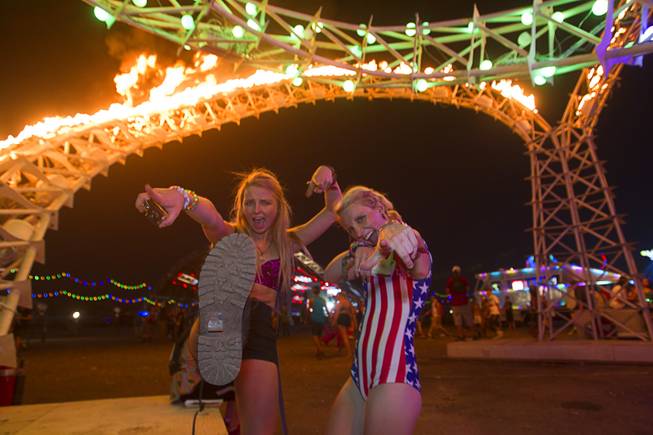 Kylie Reagan, left, and Madi Lawton of Boulder, Colo. pose under "Tympani," a sculpture by the Flaming Lotus Girls, during the final day of the 2014 Electric Daisy Carnival (EDC) at the Las Vegas Motor Speedway Sunday, June 22, 2014.