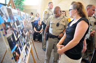 Las Vegas police and others look at a poster of photographs of Joseph Wilcox after a memorial service at Palm Downtown Mortuary and Cemetery on Sunday, June 22, 2014. Wilcox, 31, was killed trying to stop Jerad and Amanda Miller in the midst of their shooting spree at an east valley Walmart store on June 8.