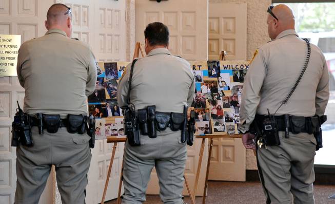 Las Vegas police officers look at a poster of photographs of Joseph Wilcox before a memorial service at Palm Downtown Mortuary and Cemetery on Sunday, June 22, 2014. Wilcox, 31, was killed trying to stop Jerad and Amanda Miller in the midst of their shooting spree at an east valley Walmart store on June 8.
