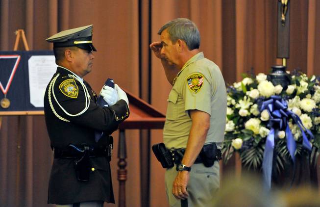 Clark County Sheriff Doug Gillespie, right, salutes an American flag before receiving it from honor guard member and police Lt. Robert Smith during a memorial service for Joseph Wilcox at Palm Downtown Mortuary and Cemetery on Sunday, June 22, 2014. Wilcox, 31, was killed trying to stop Jerad and Amanda Miller in the midst of their shooting spree at an east valley Walmart store on June 8.