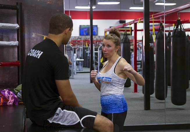 Rushelle Kiesel talks with instructor Seth Shaffer after a boxing group class at the UFC Gym at 4360 Blue Diamond Rd. Tuesday, June 24, 2014.