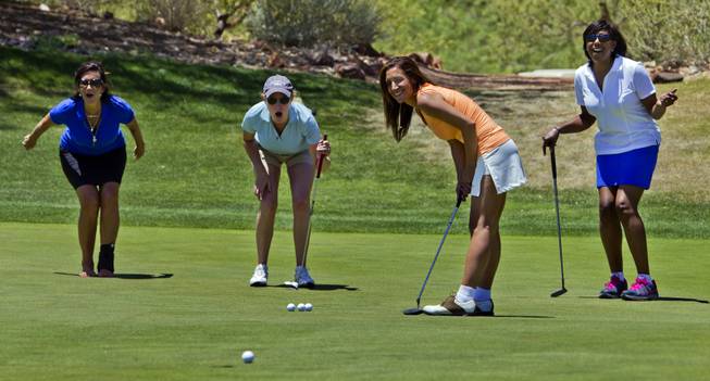 Golfers Kim Maragos, Barb Nolter, Mamta Kapoor and Kisa Cooper-Tippett urge a ball into the hole on Tuesday, June 24, 2014.  They join many others golfers as HELP of Southern Nevada hosts its 20th Annual Golfers Roundup at Cascata Golf Course in Boulder City.