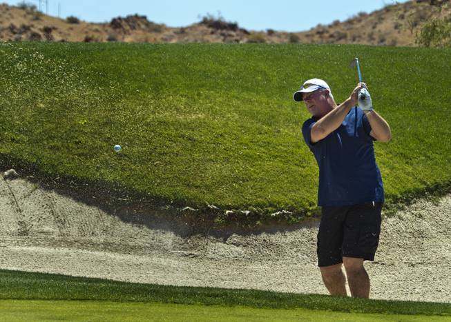 Gary Schade wedges a ball from the sand as HELP of Southern Nevada hosts its 20th Annual Golfers Roundup at Cascata Golf Course in Boulder City on Tuesday, June 24, 2014.