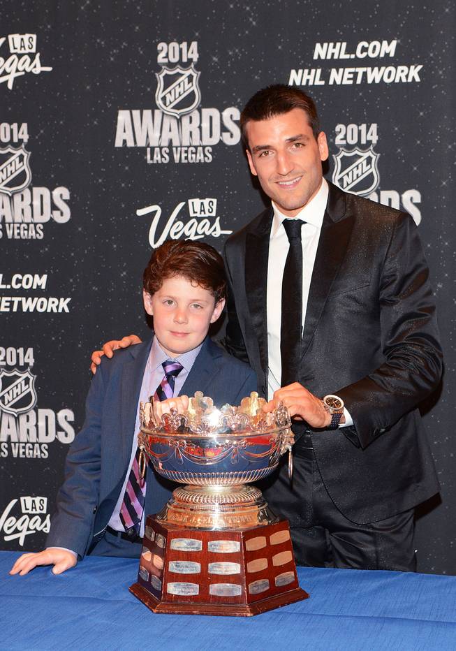 Nine-year-old Will Lacey of Boston, who is battling a brain tumor, with Patrice Bergeron of the Boston Bruins and the Frank J. Selke Trophy at the 2014 NHL Awards in Encore Theater on Tuesday, June 24, 2014, at Wynn Las Vegas.