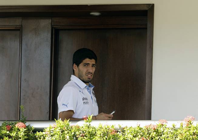 Uruguay's Luis Suarez uses his cellphone at a hotel in Natal, Brazil, Wednesday, June 25, 2014. Suarez bit Italian player Giorgio Chiellini during Uruguay's game with Italy on Tuesday, which could lead to Suarez being kicked out of the World Cup. 