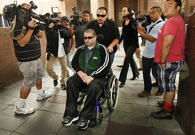 A wheelchair bound Bryan Stow, assisted by a caregiver, is surrounded by family and media as he is led into the Los Angeles County Superior Courthouse in downtown Los Angeles, Wednesday, June 25, 2014, as the trial goes into the last day before closing arguments for the trial of Stow's lawsuit against former Dodgers owner Frank McCourt and three team entities he created. 
