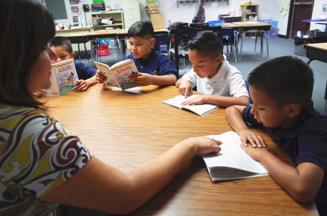 Cortez Elementary School teacher Shasta Thompson reads with third graders (l-r) Isaiah Corona, 9; Uziel Umana, 9; Rafael Lucio, 9; and Reily Armenta, 8; on Monday, June 22, 2014. Cortez is one of 14 "Zoom Schools" in Clark County that is receiving 17 additional days of school this year to help English-language learner students retain their literacy skills over the summer.                                                             