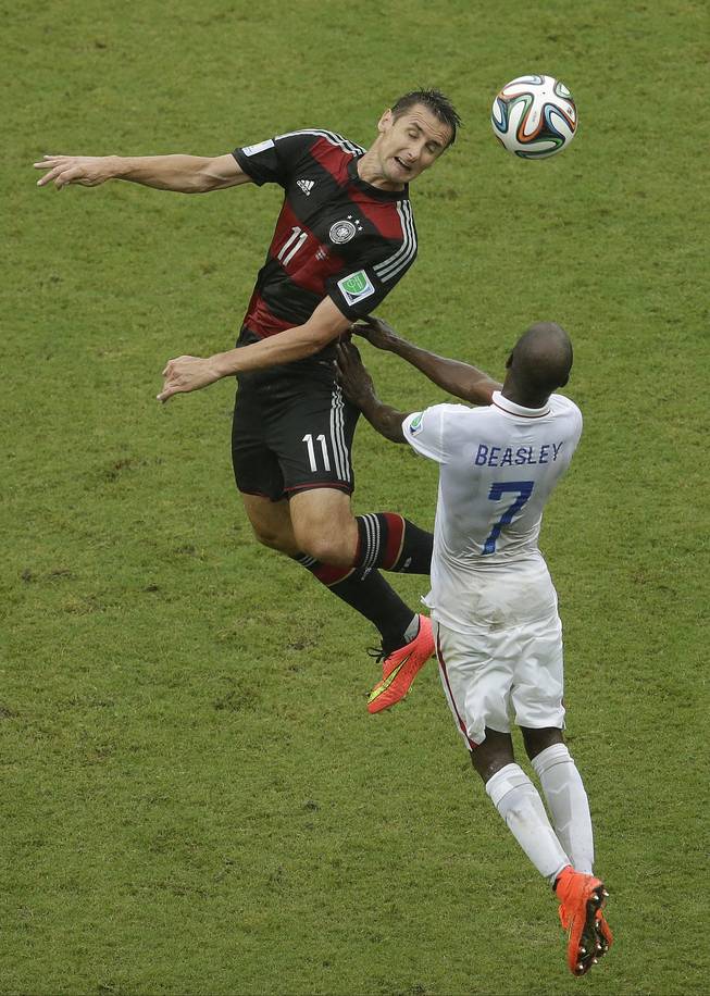 Germany's Miroslav Klose and United States' DaMarcus Beasley (7) go up for a header during the group G World Cup soccer match between the USA and Germany at the Arena Pernambuco in Recife, Brazil, Thursday, June 26, 2014. 