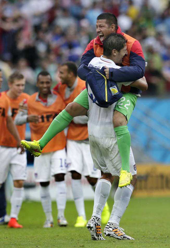 United States' goalkeeper Nick Rimando, right, celebrates with Omar Gonzalez after advancing to the round of 16 despite a 0-1 loss to Germany after the group G World Cup soccer match between the USA and Germany at the Arena Pernambuco in Recife, Brazil, Thursday, June 26, 2014. 